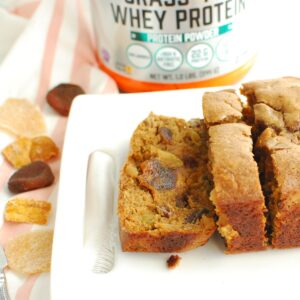 Healthy fruitcake with a slice cut into it on a white plate.