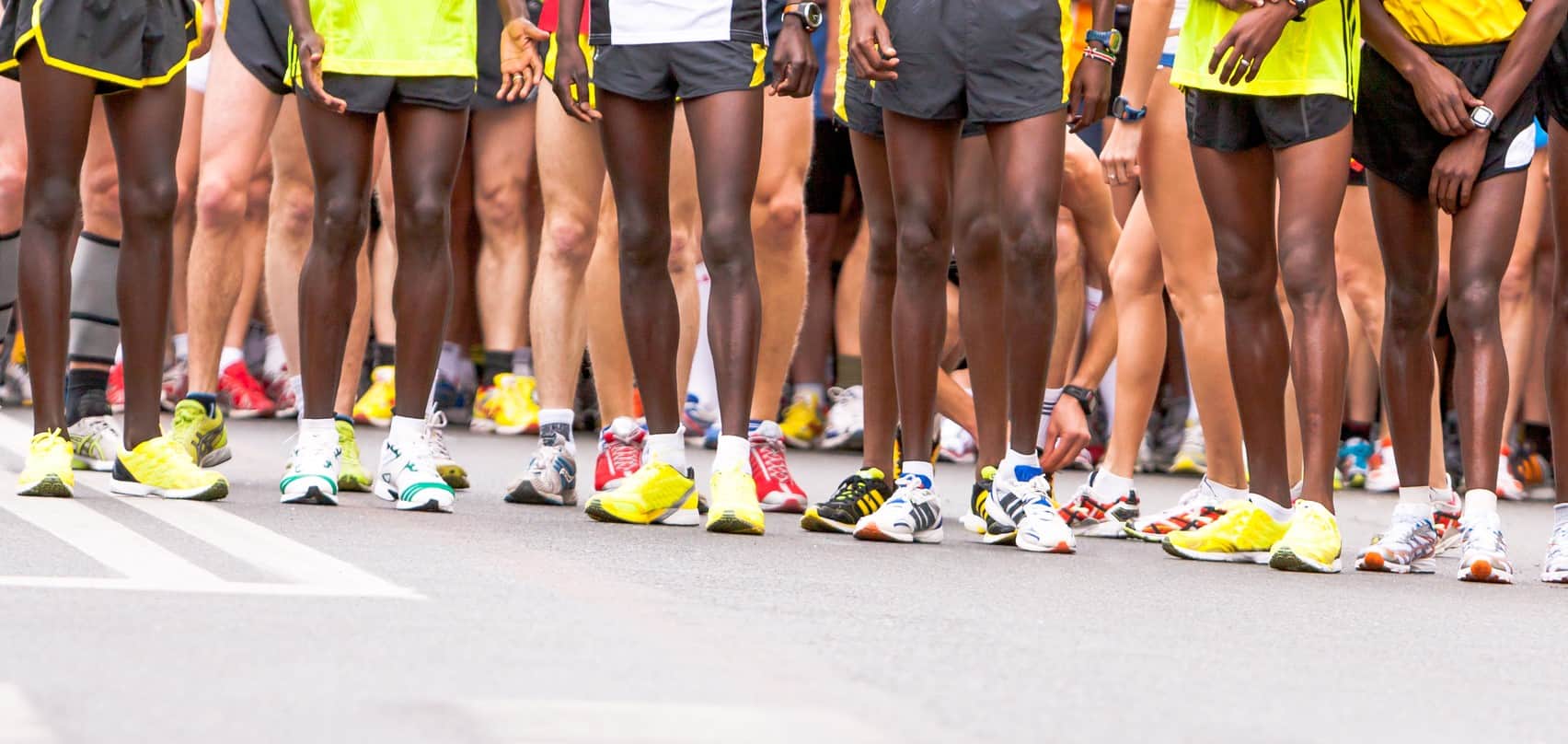 The legs of people at the starting line of a half marathon race.