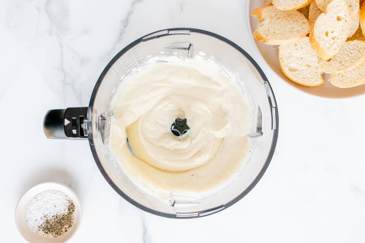 Whipped ricotta in a food processor bowl.