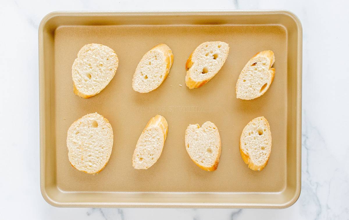 Sliced bread on a baking sheet.