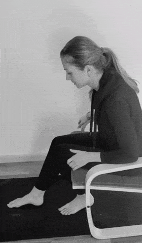 A woman doing a seated foot exercise.