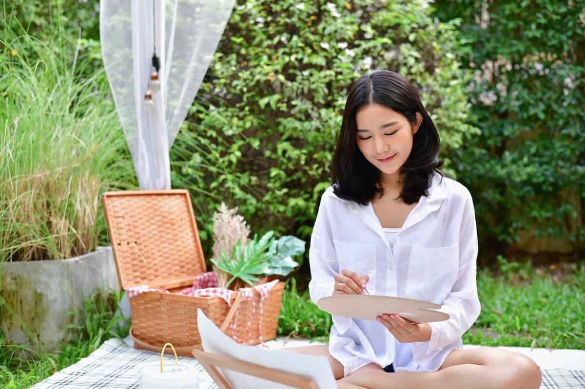 A woman painting outside on a nice spring day.