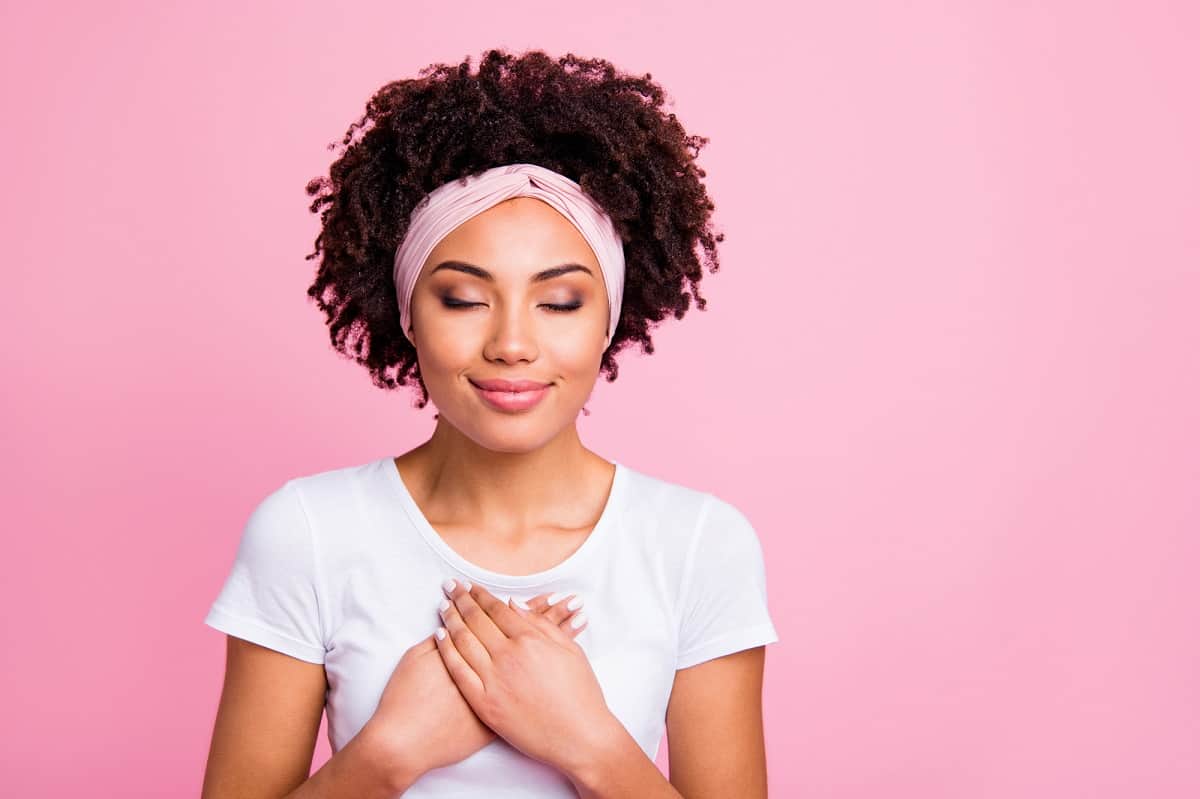 A woman closing her eyes and feeling grateful.