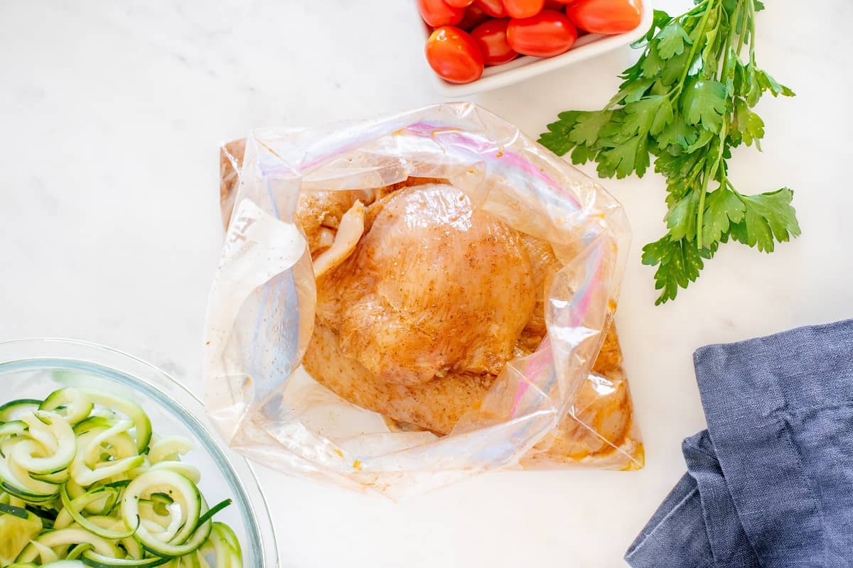Chicken in a zip top bag tossed with oil and cajun seasoning.