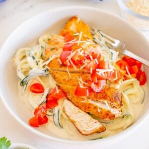 A bowl filled with creamy zoodles and cajun seasoned chicken.