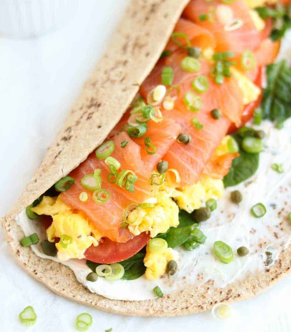 A smoked salmon breakfast wrap on marble countertop.