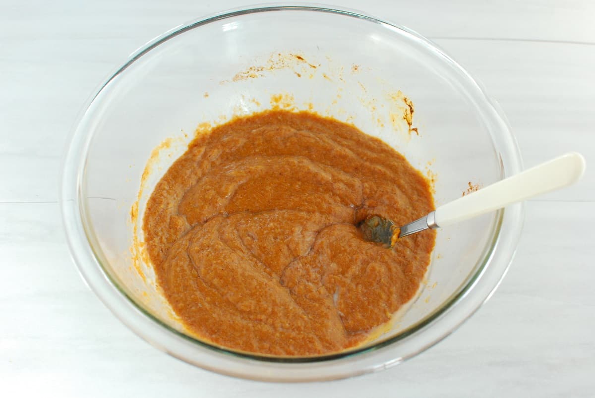 Pumpkin puree, coconut sugar, applesauce, coconut oil, eggs, pumpkin spice, and vanilla mixed together in a bowl.