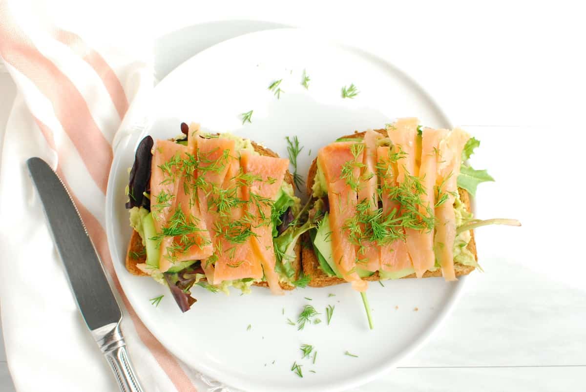 Two pieces of smoked salmon breakfast toast topped with dill.