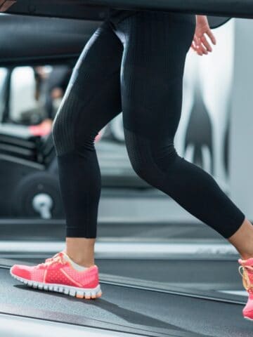 A woman walking on the treadmill at an incline.