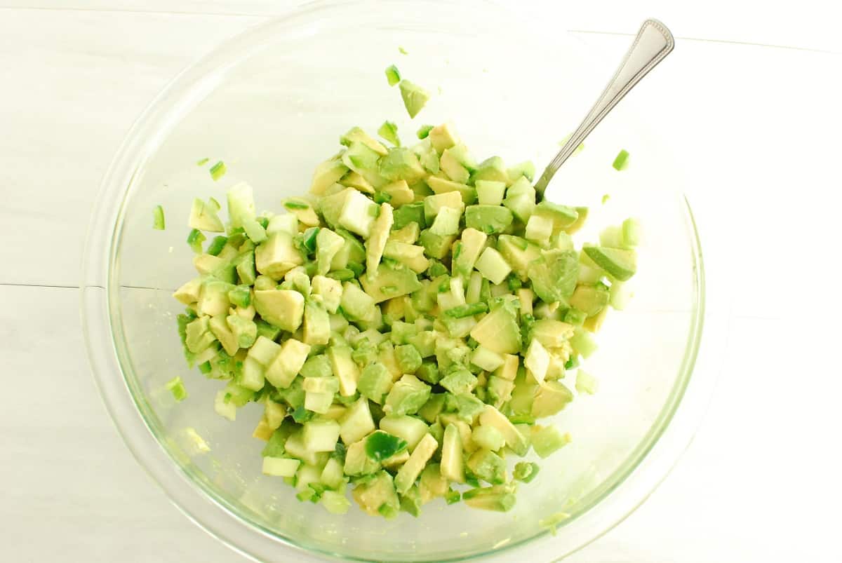 Avocado, cucumber, lime juice, and salt mixed together in a bowl.