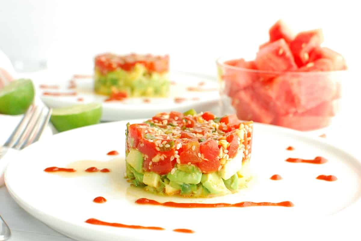 Watermelon tartare on a plate with some sriracha drizzle.