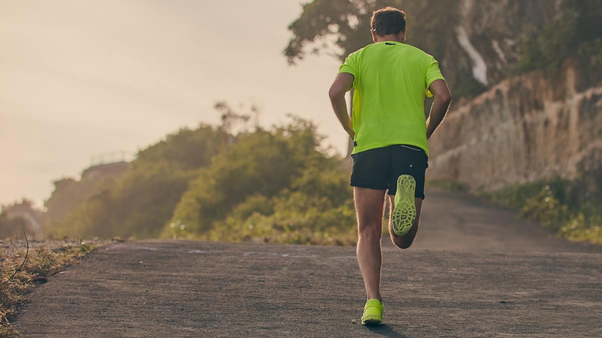 A man running on a quiet dirt road.