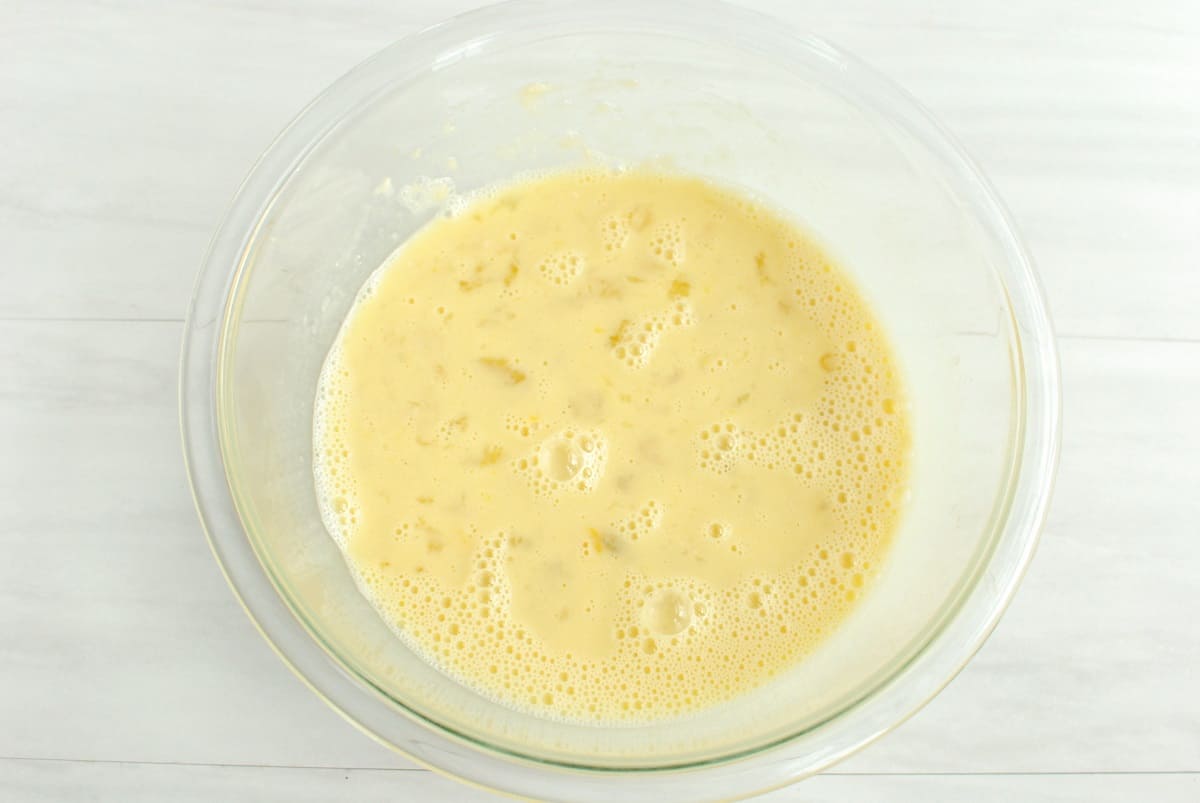 Bananas, peanut butter, honey, eggs, and oat milk whisked together in a mixing bowl.