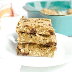 Three gluten free chocolate chip oatmeal bars stacked on a white plate.