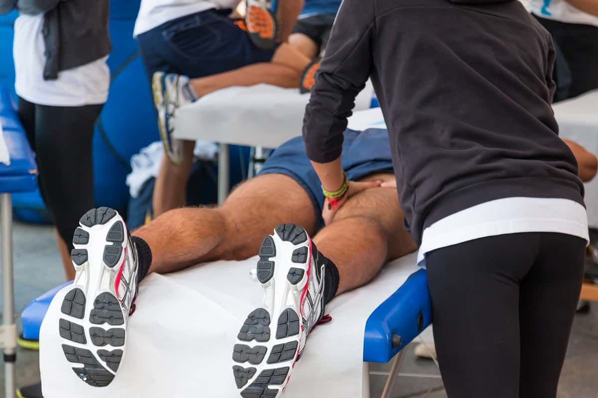 An athlete getting a massage on his calves and hamstrings.
