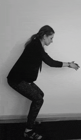 A woman doing squat jumps.