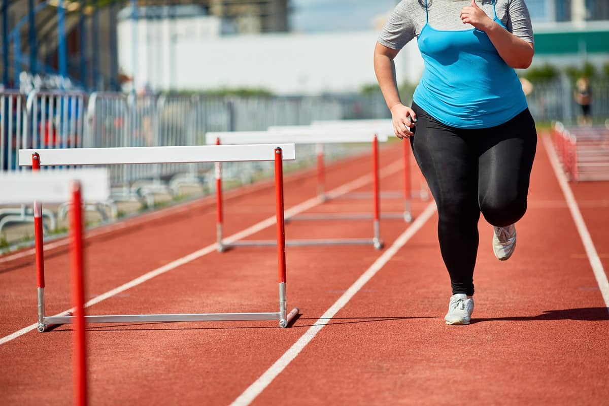 A woman doing a mile repeat on a track.