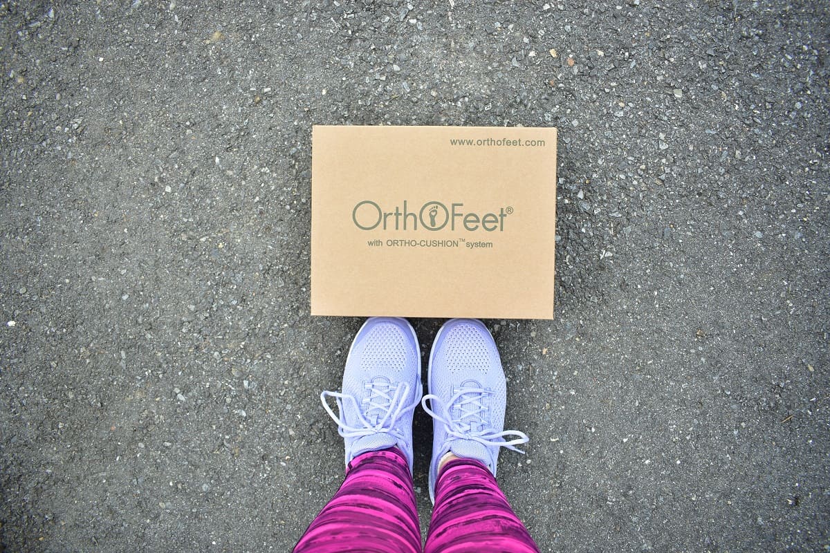 A woman's feet next to an Orthofeet shoe box.