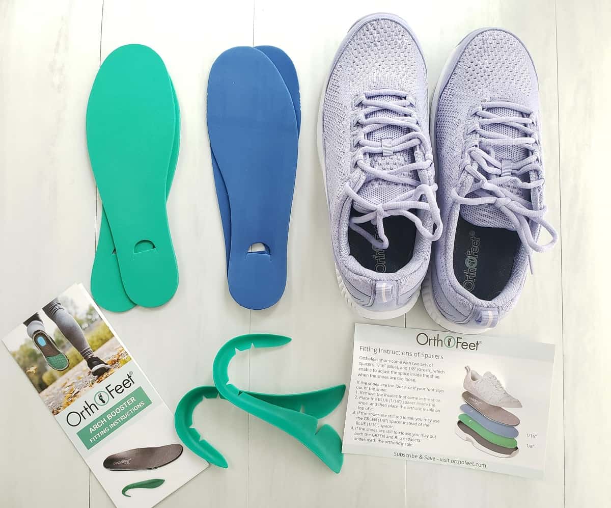 A pair of sneakers, two sets of spacers, arch support boosters, and instructions.