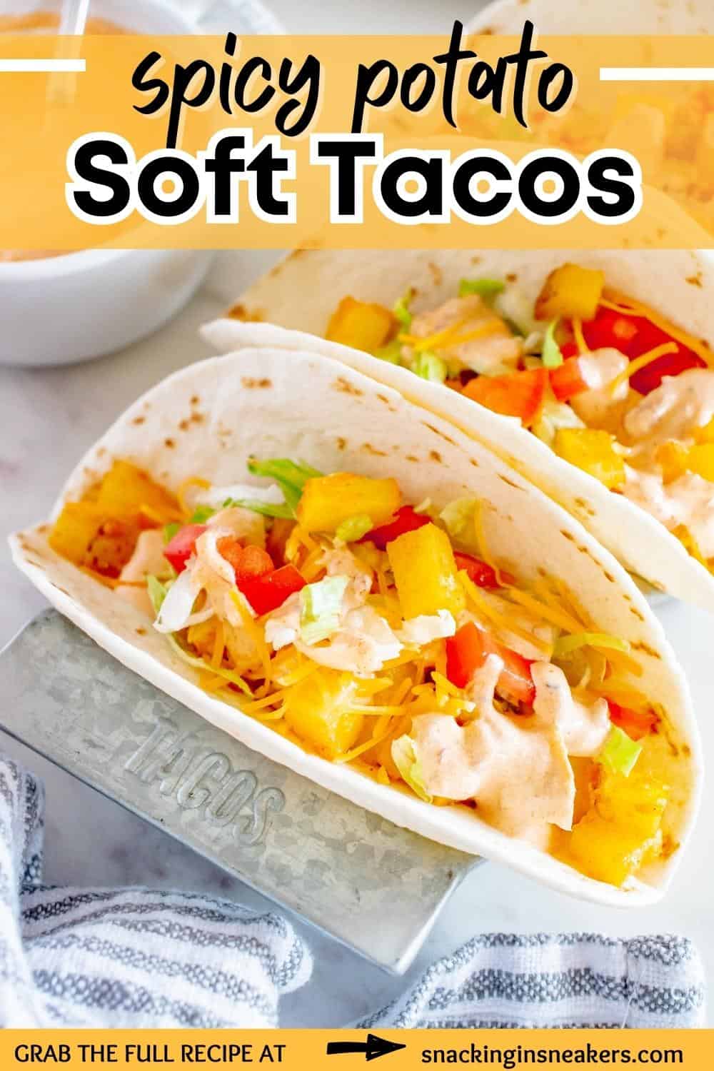 A spicy potato soft taco in a metal rack, next to a blue and white napkin.