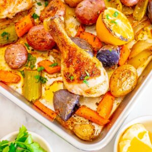 Cooked sheet pan chicken drumsticks and veggies.