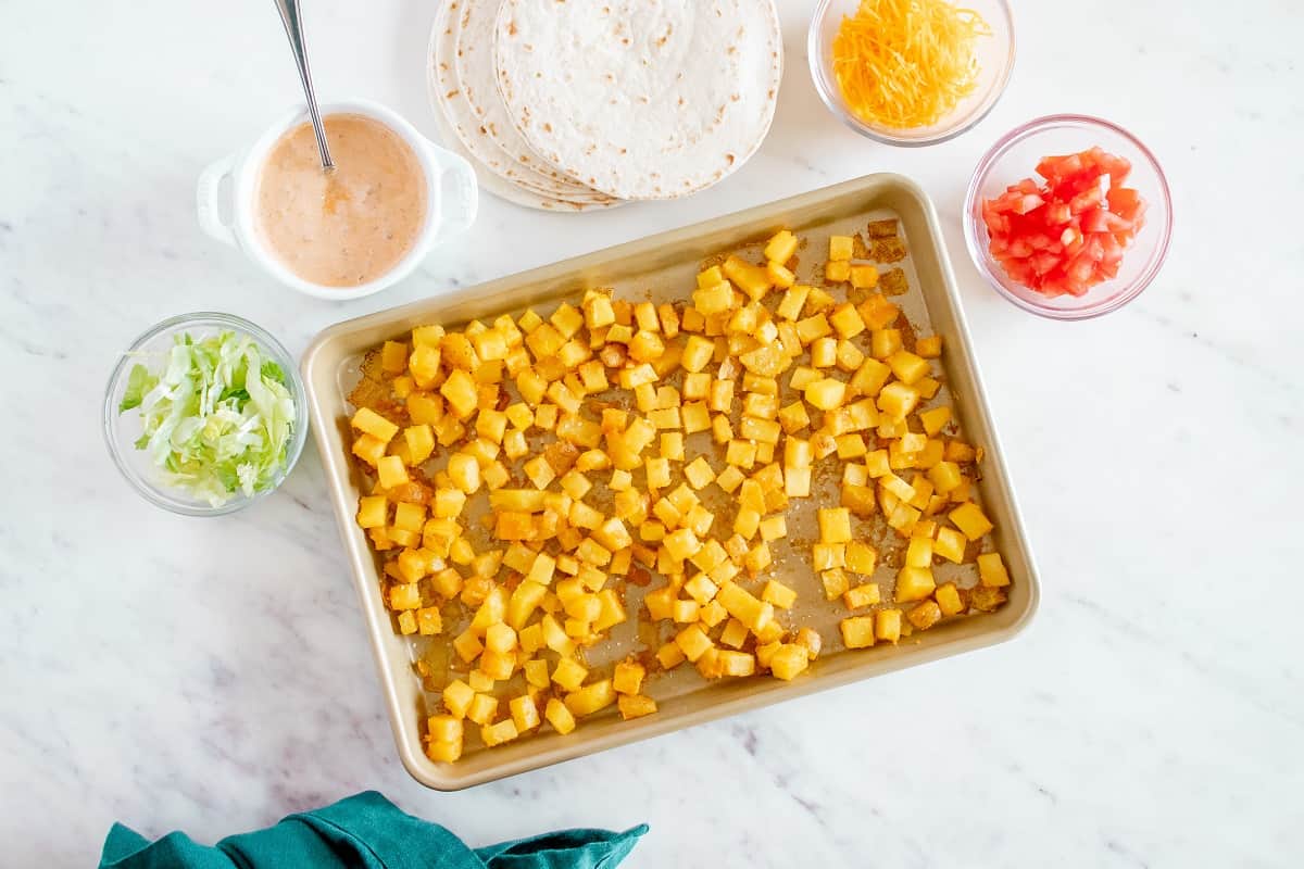 Roasted spicy potatoes on a baking sheet.