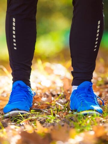 A runner's shoes standing on a path in the fall.