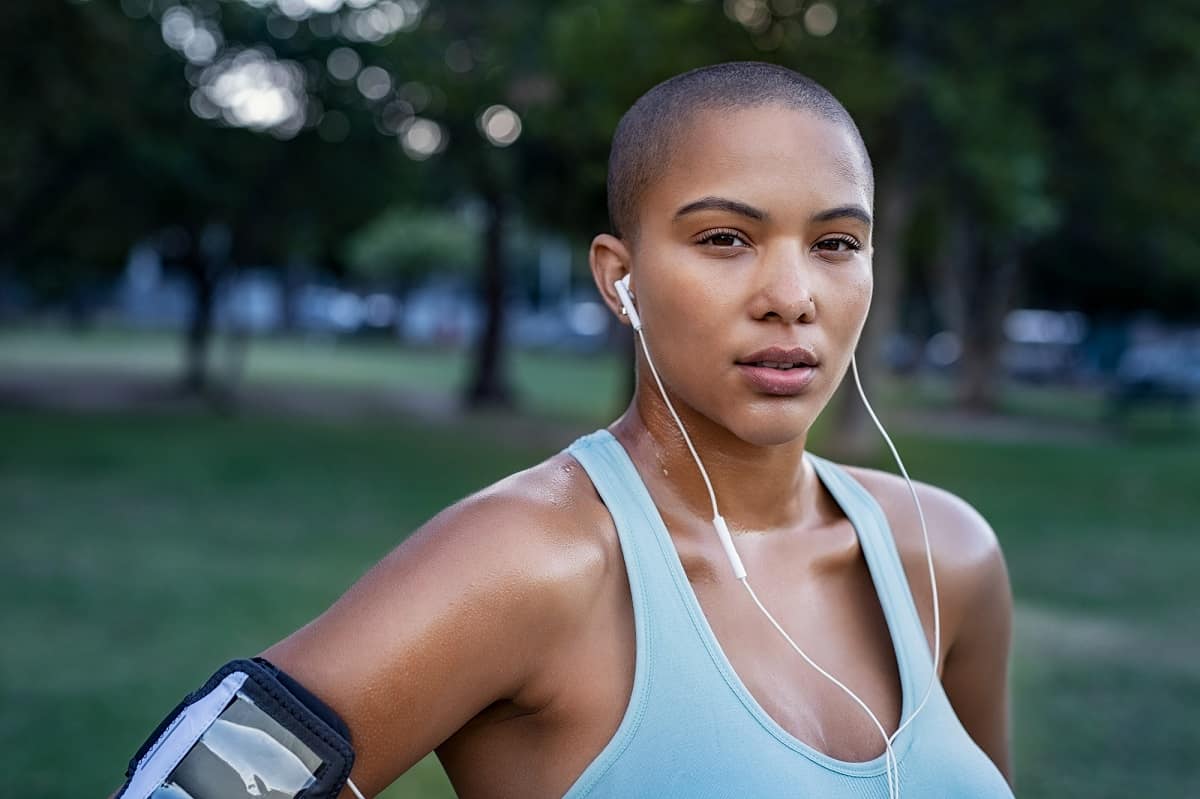 A woman standing outside sweaty after a half marathon training run.