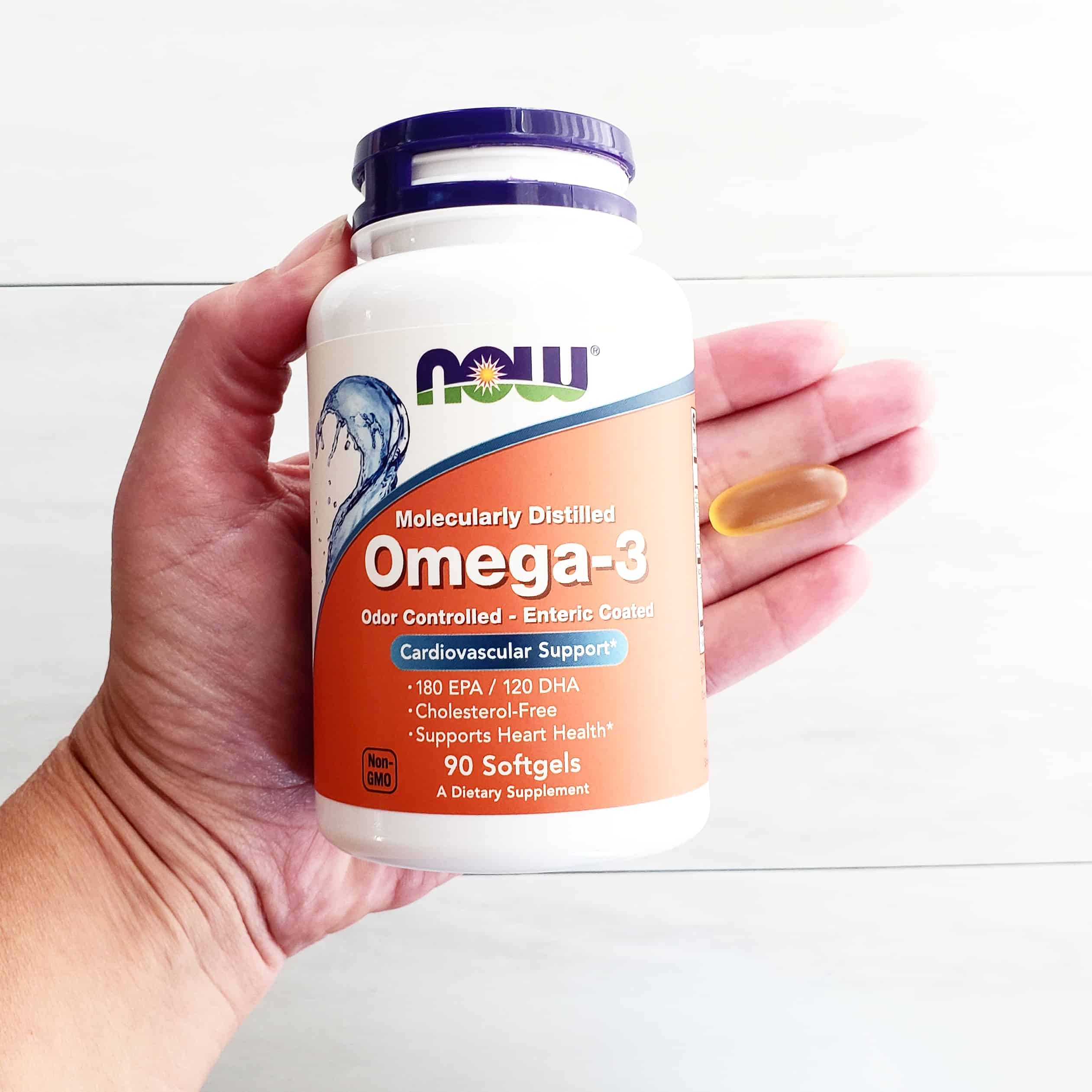 A bottle of omega-3 fatty acids in a woman's hand.