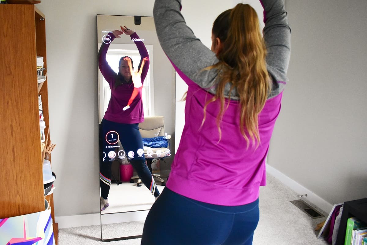 A woman doing dance exercise in front of the lululemon mirror.