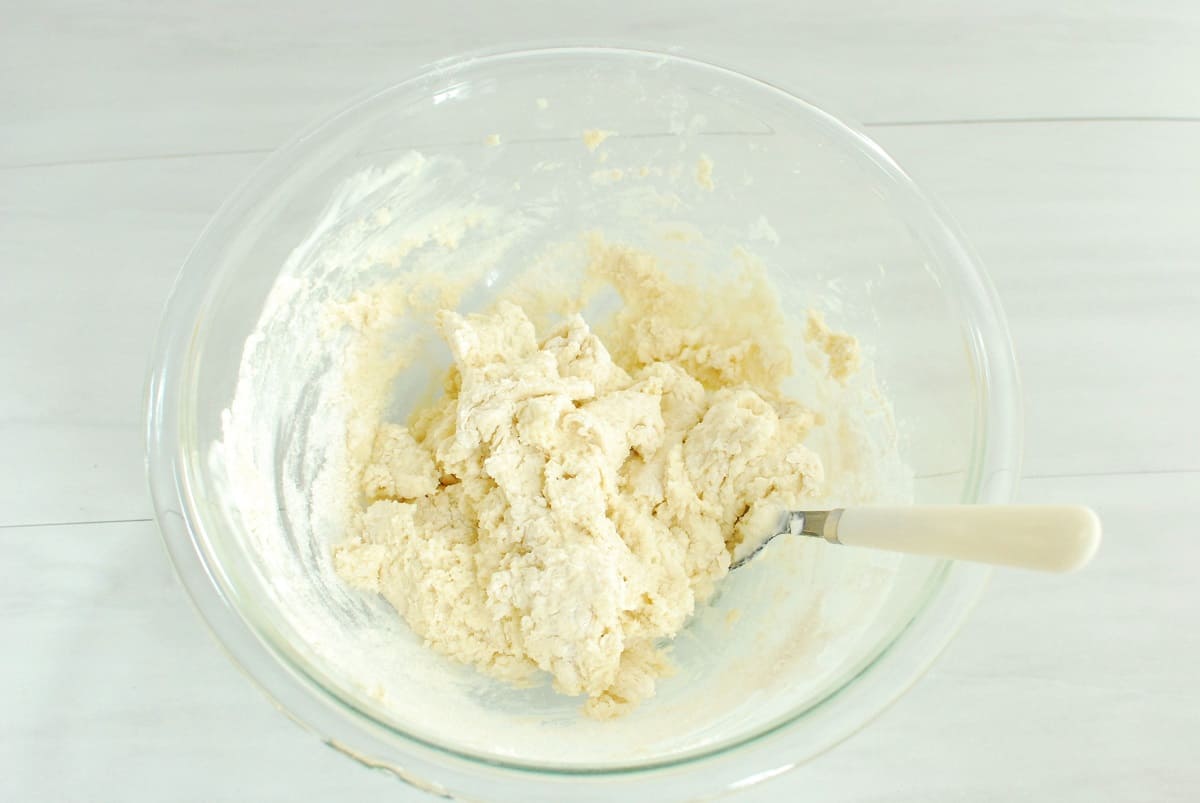 Bagel dough in a glass mixing bowl.