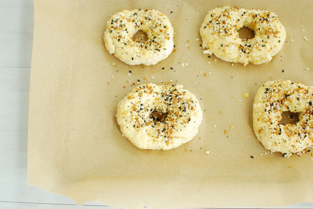 Bagel dough brushed with egg wash and sprinkled with everything bagel seasoning.