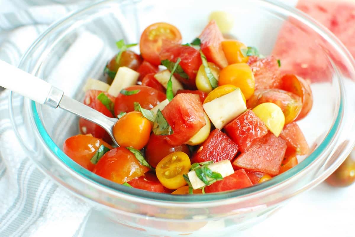 A close-up of a bowl filled with watermelon, tomato, and mozzarella salad.