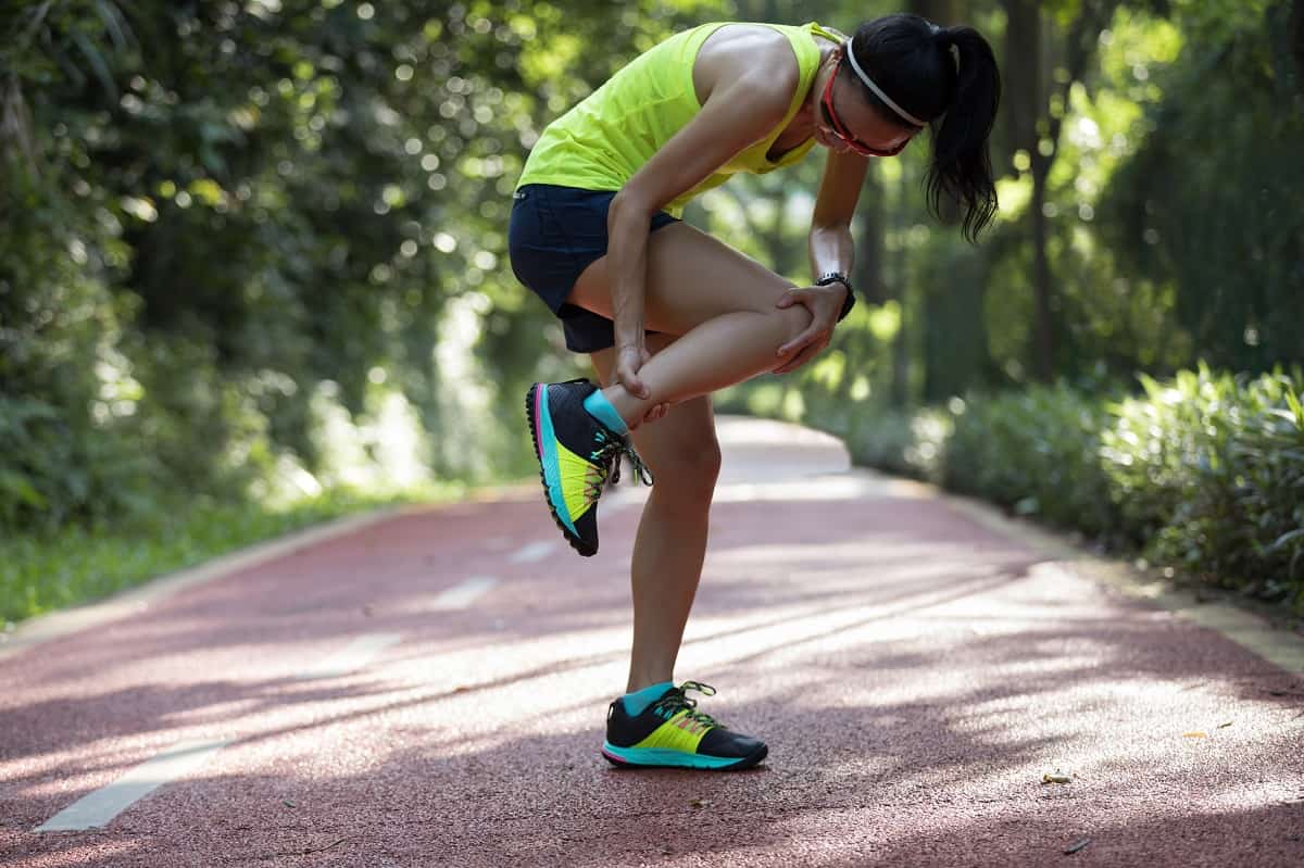 A woman struggling with shin splints on a run.