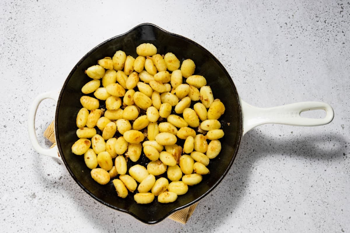 Gnocchi being sauteed in a skillet.