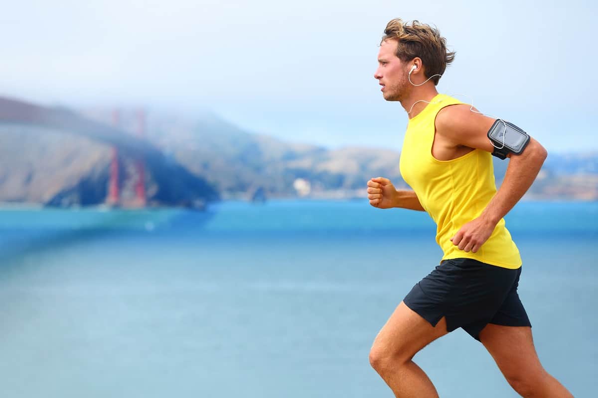 A male runner trying some running hacks on a run by the water in San Francisco.