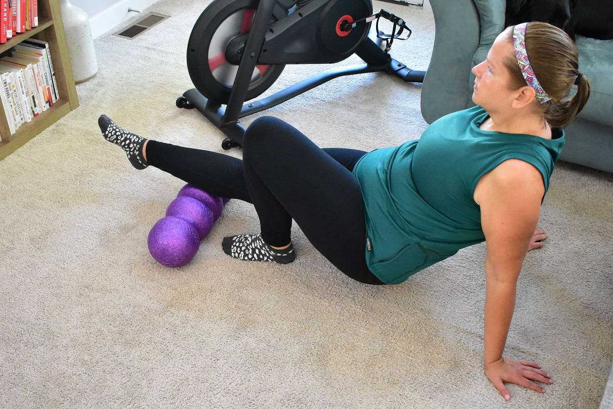 A woman rolling her calves on the Rollga foam roller.