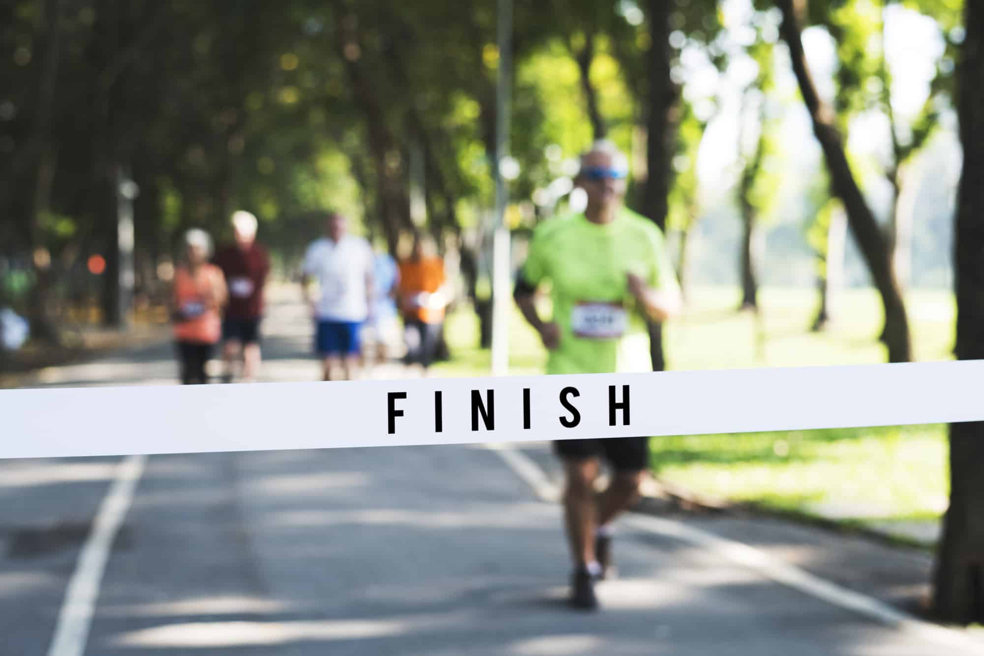 A man running towards the finish line of a road race.