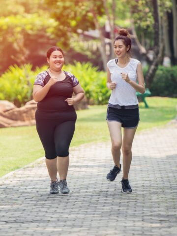 Two friends learning how to run outside together.