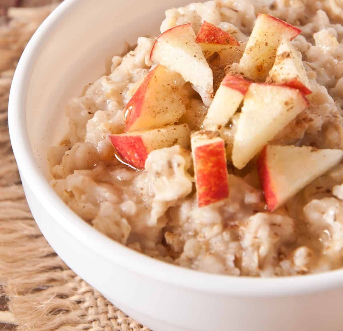 A bowl of protein oatmeal topped with diced apples.