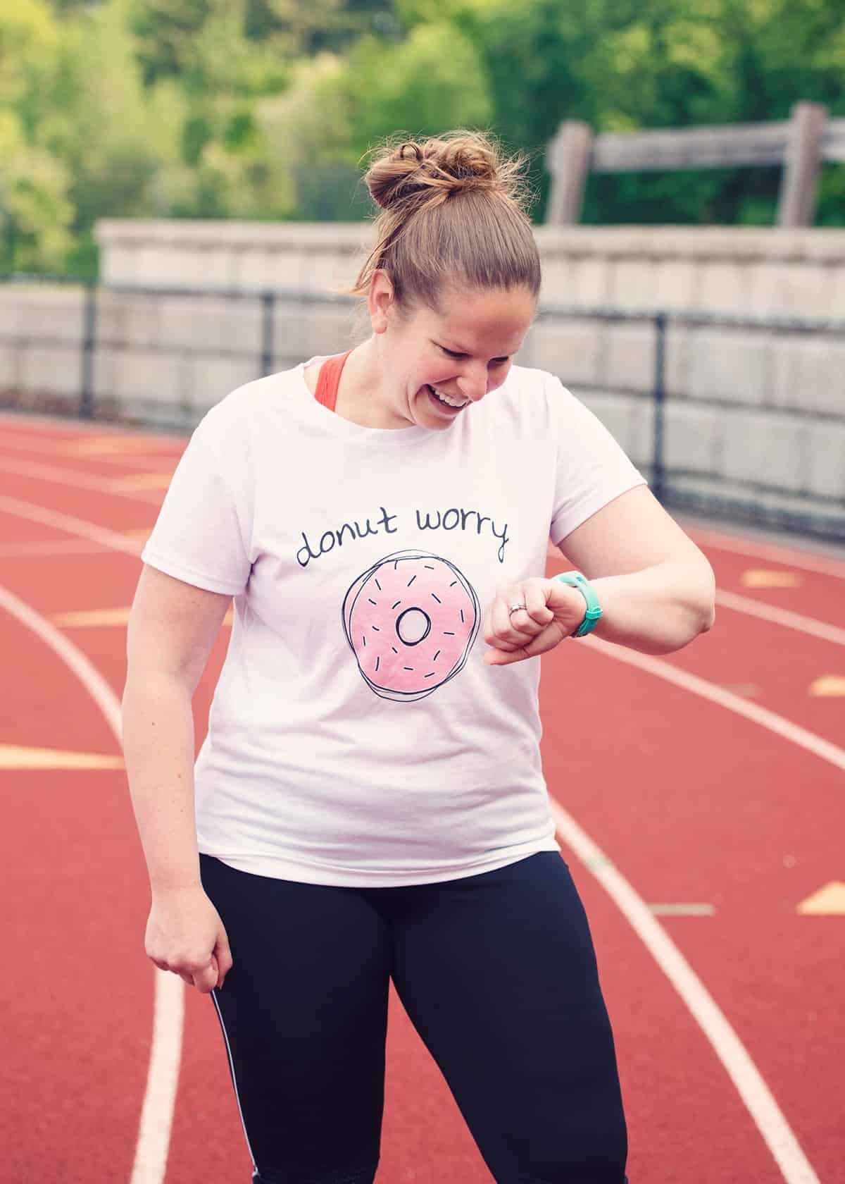 Coach Chrissy at a track looking at her watch.