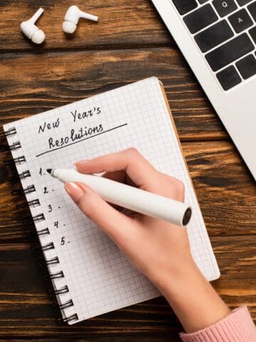 A notebook where someone is writing down new year's resolutions for 2024.