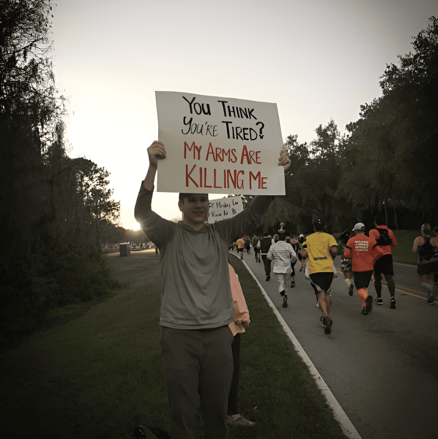 A man holding up a race day sign that says 