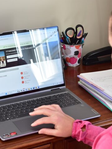 A woman completing the Fit4Mom certification at her desk.