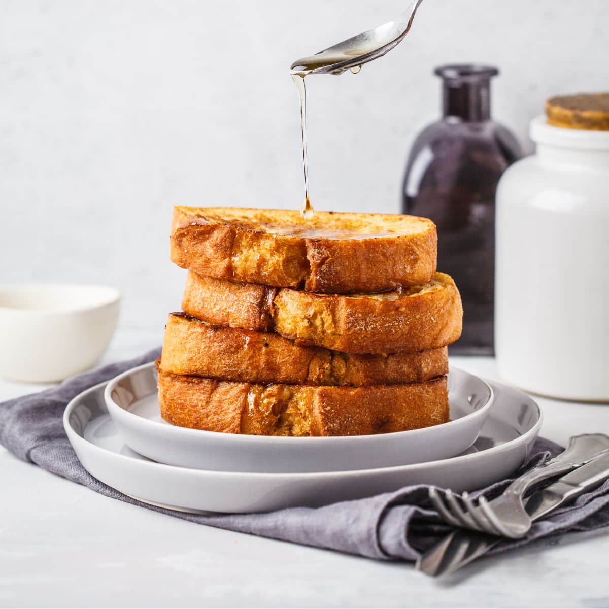 A stack of protein French toast being drizzled with syrup.