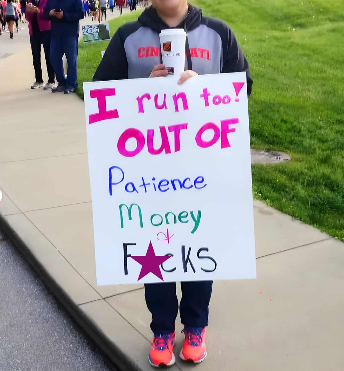 A person holding a funny sign at a race that says 