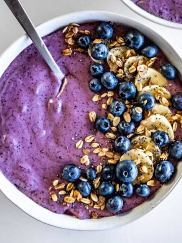 Overhead shot of a blueberry smoothie bowl topped with granola, blueberries, and banana.