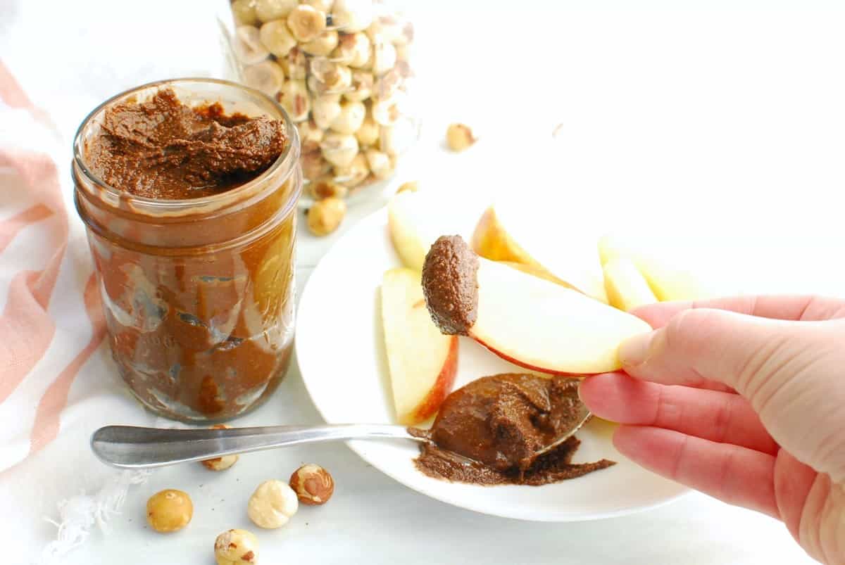 An apple sliced dipped in homemade chocolate hazelnut spread.