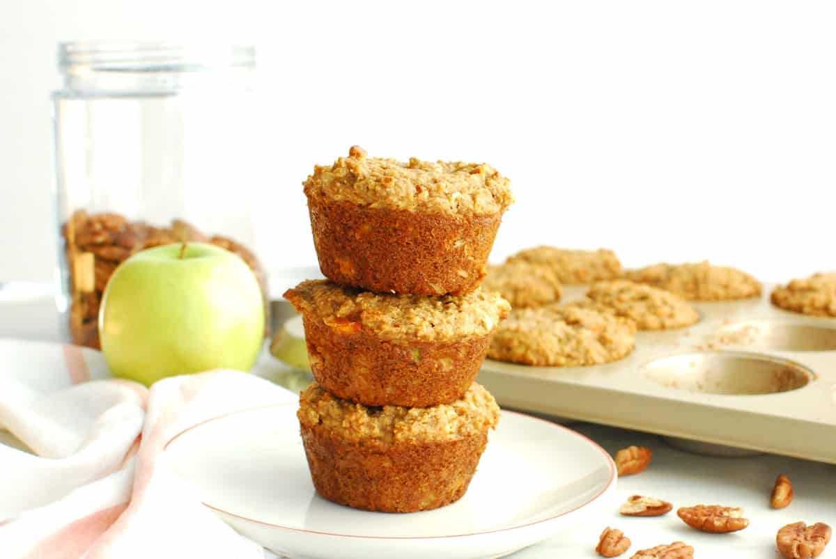 Three morning glory muffins stacked on top of each other on a small plate.