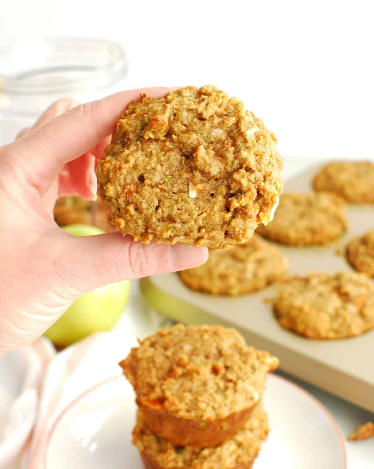 A woman's hand holding a healthy morning glory muffin.